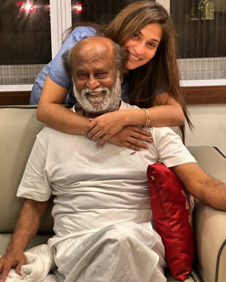 Aishwarya Rajinikanth with her arms around her father Rajinikanth during a festive evening