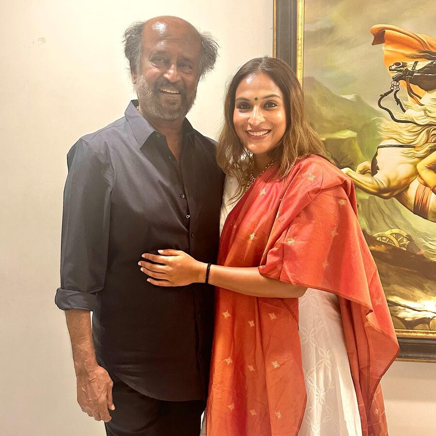 Aishwarya Rajinikanth in a coral dupatta standing with her father, the actor Rajinikanth