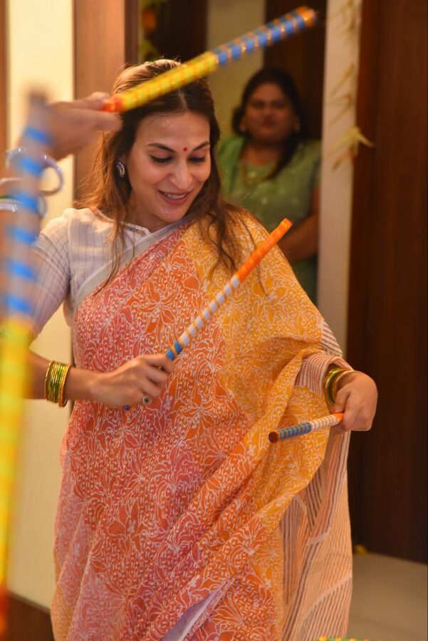 Aishwarya Rajinikanth performing a kolattam stick dance in an orange saree
