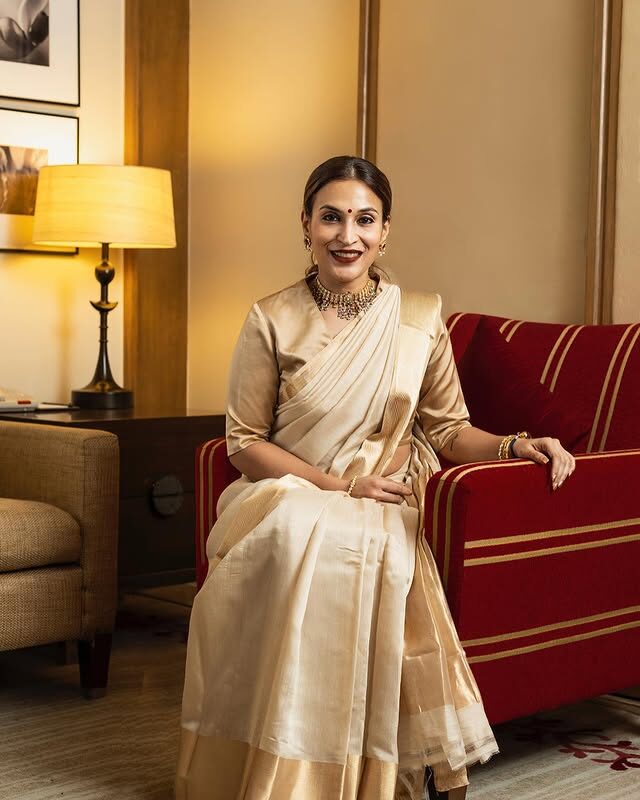 Aishwarya Rajinikanth seated in a cream handloom saree in a hotel lounge